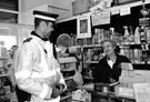 Police Community Support Officer talking to shop assistant in Kath Rose's hardware shop, Margetson Crescent