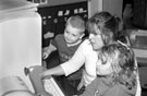 Nursery nurse Maria Parker working with children on the computer at Denby Street Nursery, Highfield