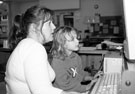 Nursery nurse Maria Parker working with children on the computer at Denby Street Nursery, Highfield