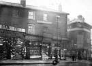 View: s13083 Angel Street at junction with Bank Street towards Snig Hill, No. 21 Cash and Co., boot makers, No. 23 Joseph Greenwood, hatter, No. 25 Fred Dover, confectioner, No 27, Herbert Bingham, umbrella manufacturer, No. 29 F.C. Webb, hosier and glover