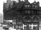 View: s18780 Pinstone Street at junction with Charles Street, No. 107 Neville Reed Ltd., tailors and Lea-Scott Ltd., opticians