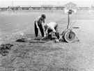 Repairing the turf at Beighton Sports Ground, High Street. Beighton junction in background