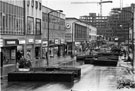 View: s23185 Pedestrianisation of the The Moor showing Visionhire; Neales Ltd., ladies outfitters; Mothercare; March the Tailor; Halfords; John Collier, tailors; Cavendish Furnishers and Lloyds Bank looking towards Manpower Service Building under construction