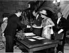 View: s28432 Colin Straw, secretary to the Lord Mayor, handing a pen for Queen Elizabeth II and HRH Duke of Edinburgh to sign the visitors book in the Town Hall with Lady Mayoress Mrs. Richardson in the background