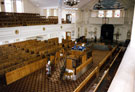 Interior of Wilson Road Synagogue looking towards the Ark showing the Reader's Desk in the centre of the hall, the mens benches and the womens gallery above