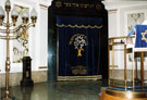 Interior of Wilson Road Synagogue showing the Ark and Menorah (left)