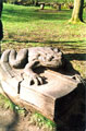 A Toad resting on a book carved from a single piece of wood entitled : A Feeled Guide to Amphibians, by Jason Thomson, situated between the cafe and the playground, Endcliffe Park