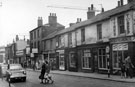 View: y00020 Nos. 19 - 35 Division Street looking towards Cambridge Street, including No. 35 Standard Hygiene Co., Surgical Stores, Nos. 31 - 33 Sheffield Transport Department, Lost Property Office, No.  29 Camille Boutique Ltd., ladies outfitters