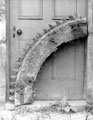 Part of a Cogged Wheel in front of a Doorway