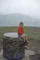 View: a04590 Richard Teasdale, son of Bob Teasdale, sitting on the Trig point on top of Lose Hill with Win Hill in the background.