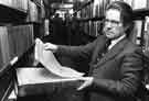 View: s31838 David Bromley, Deputy City Librarian, examining newspapers in the Basement Stack area, Central Library, Surrey Street