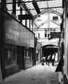 View: s41922 Cambridge Arcade, off Pinstone Street connecting to Union Street showing (right) Barney Goodman, tailors and (left) Haywood's Travel and Sheffield United Tours Ltd