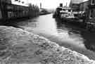 View: s43887 River Don from Lady's Bridge running high showing (left) Exchange Brewery, Bridge Street and (right) Direct Paints Ltd., decorators merchants, Nos.13-19 Nursery Street