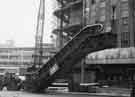 View: s44334 High Street and the lifting of escalators for the construction of Castle Square showing (left) Clerical, Medical and General Life Assurance Society Offices and (right) the construction of J.Walsh and Co., department store