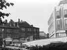 View: s44876 Car park on Norfolk Street alongside (right) the Town Hall extension (Egg Box (Eggbox)) showing (l.to.r.) No.182 J.and K. Jones Ltd., jewellers, Basil's pancake bar, and No.176 Hearing Aid Services