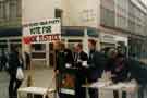 View: t10708 Green Party election stall (whatever your party vote for trade justice) on The Moor showing (centre) Trustee Savings Bank