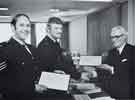 View: y13694 The Chairman of the Police Authority, County Councillor E. Fox, JP, presenting Sergeant Scothern and Constable Ford with certificates from the Society for the Protection of Life from Fire - April, 1977