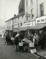 Market traders on Dixon Lane showing (l. to r.) No. 26 Norfolk Arms public house; No. 24 T. Bates (Wallpapers) Ltd., paint merchants; No 22, William John King Ltd., provision dealers; No. 20 Dewhurst, butchers and No. 18 Home Farm Products, butchers