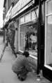 Painting the shop frontage of Anne's, childrenswear, Sharrow Vale Road, c.1970s