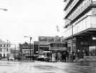 View: s46566 Waingate showing (centre) entrance to Castle Market (right) No. 2 Bunneys (Hosiery) Ltd., drapers, No. 4 Rusby, opticians, No. 6 Wymans Ltd., ladies outfitters, (left) No. 30 Dawson Brothers Ltd., fabric specialists 