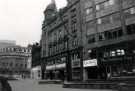 View: t12281 Fargate showing (l. to r.) Nos. 62 - 64 Joan Barrie Ltd., ladies fashions; No. 58 Burnley Building Society; Nos. 54 - 56 (first floor) La Coupe, unisex hairdressers and Nos. 54 -56 The Golden Egg Restaurant