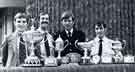 View: y13847 Police Constables P. Blakeney (left) and A. Flynn (2nd left) with Police Sergeant R. Aconley (2nd right) and Police Constable J. Dunphy with some of the athletic trophies they won during the 1979 season